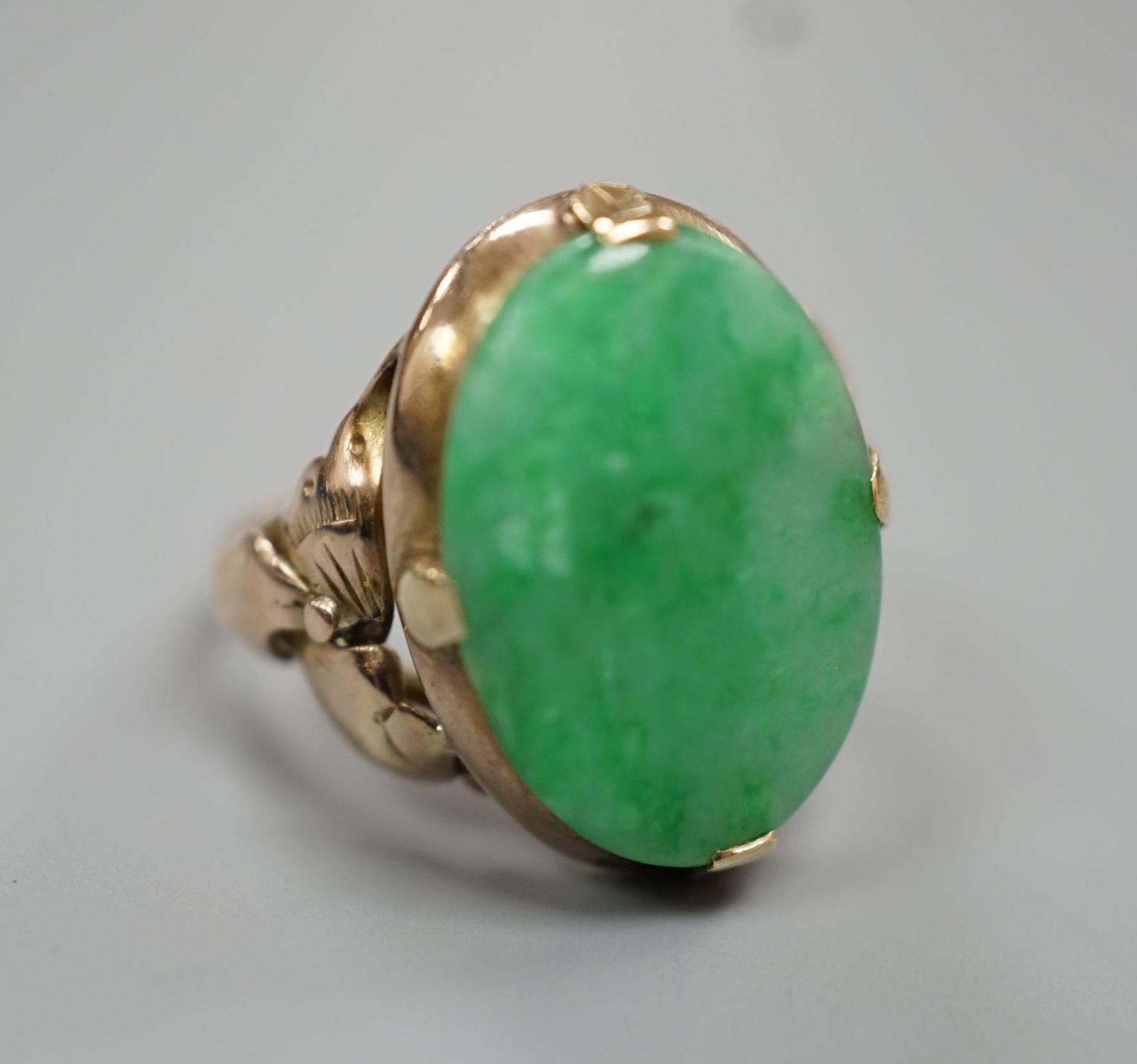 A yellow metal and oval cabochon jade set ring, size K/L, gross weight 3.5 grams.
